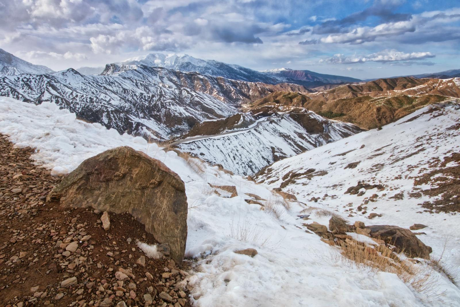 Atlas Mountains adventure team building activity with corporate group hiking and outdoor leadership exercises, dramatic mountain landscape, professional outdoor team building setup