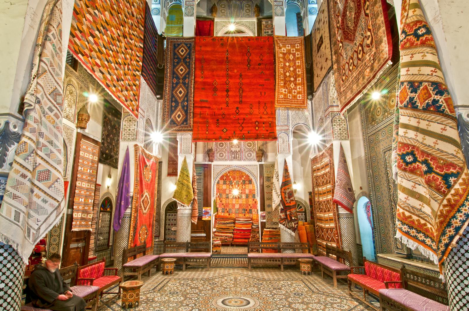 Traditional Moroccan souk market in Agadir with corporate team doing cultural treasure hunt activity, colorful spices and traditional crafts, authentic local experience for business groups